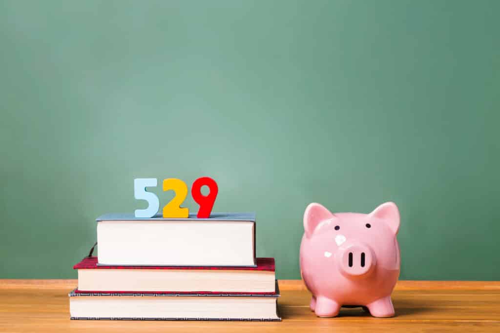529 plans theme with textbooks and piggy bank and green chalkboard background